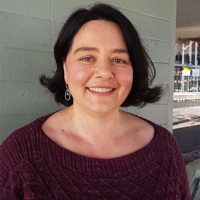 Woman wearing a maroon sweater with a neutral background