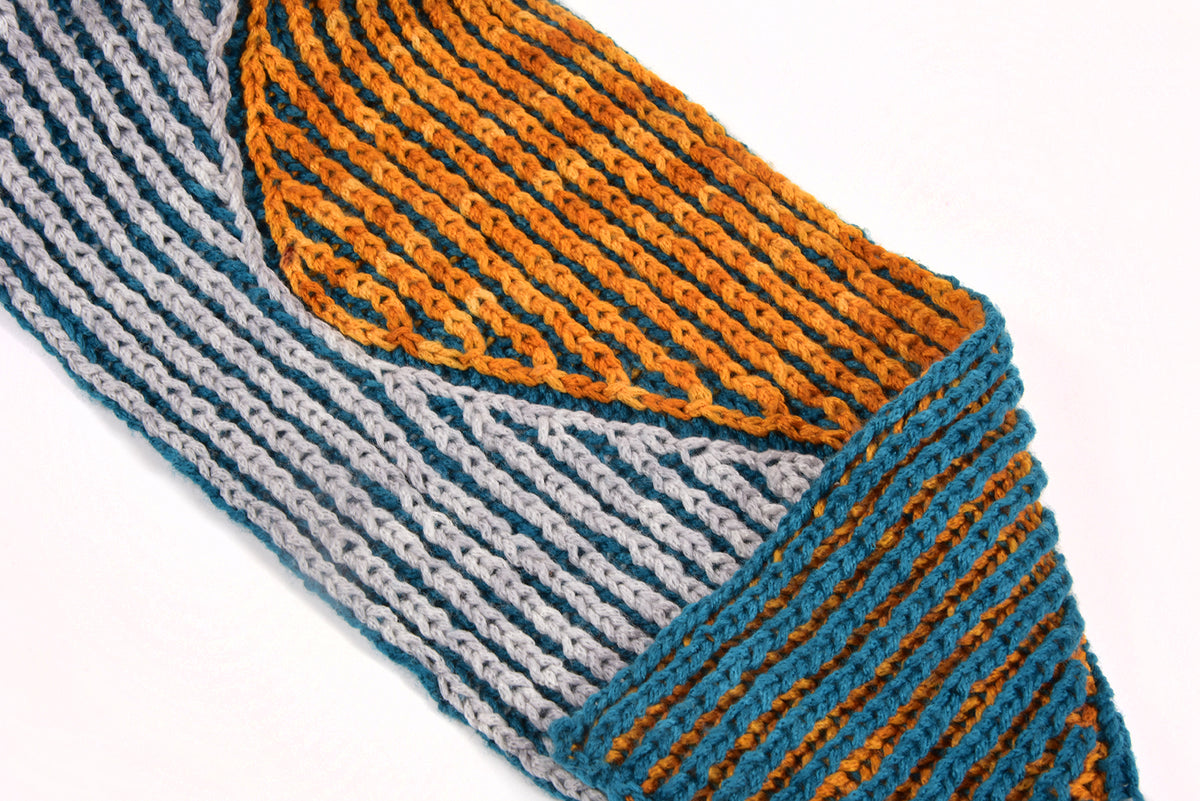 Close-up of colour-blocked brioche knitting in orange, teal and grey