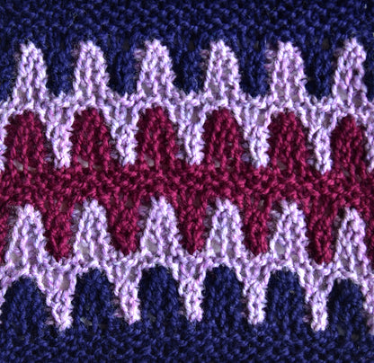 Close-up of stacked stitches in purple, lilac and magenta zigzags
