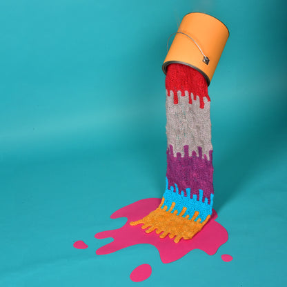 Stacked stitch drips knitted in bright stripes pouring from a paint tin